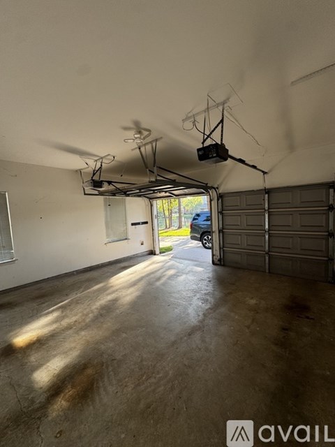 A large empty garage with a car parked in the background.