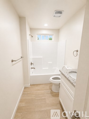 A white bathroom with a toilet, sink, and bathtub.