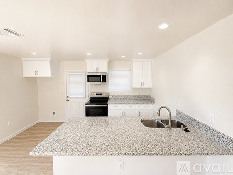 A kitchen with granite countertops and white cabinets.