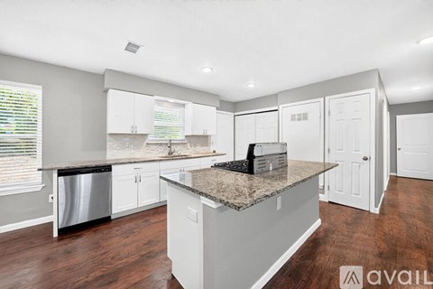 A kitchen with a granite countertop and white cabinets.