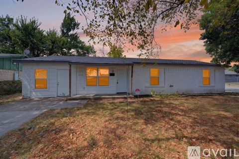 A house with a grey exterior and orange windows is available for rent.