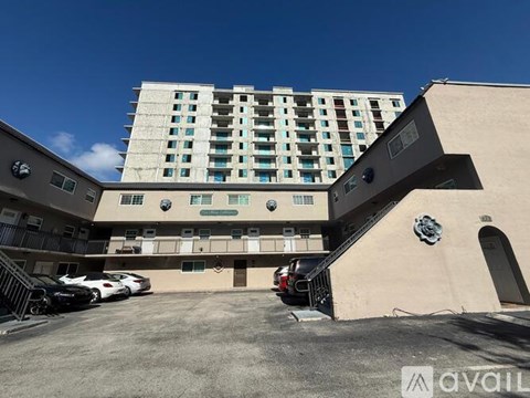 A modern building with a parking lot in front.