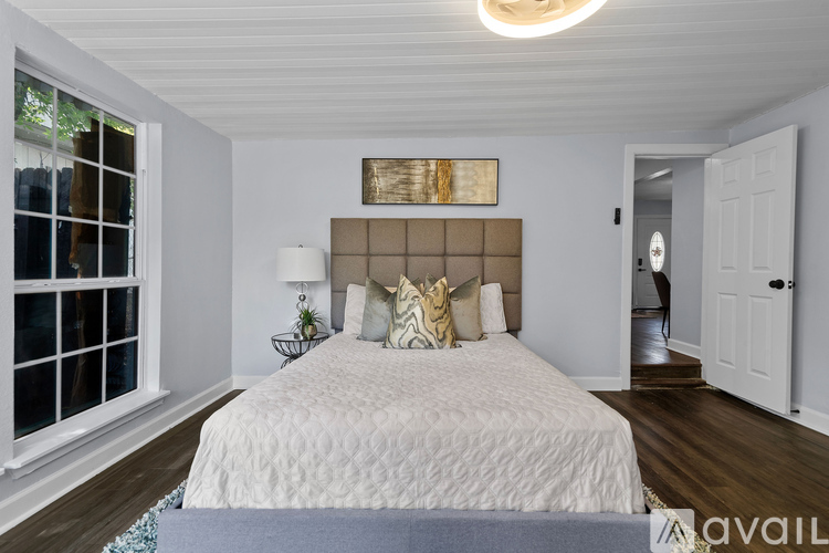 A bedroom with a large bed and a painting above it.