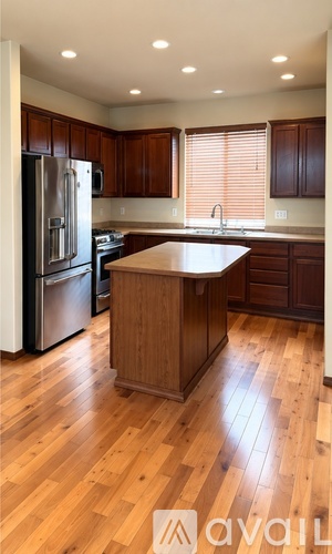 A kitchen with wooden floors and a center island.