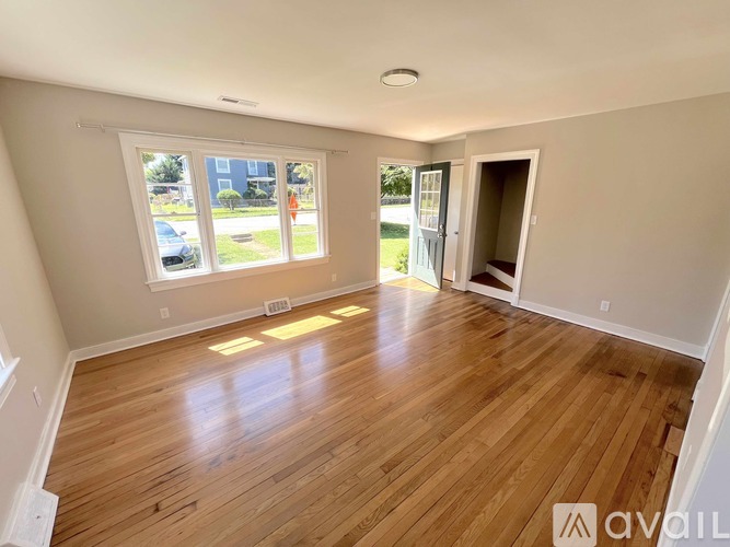 A room with wooden flooring and a window overlooking a street.