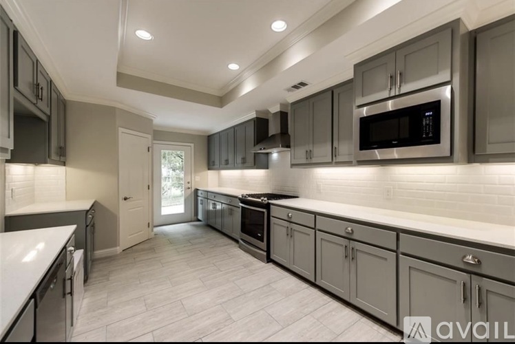 A modern kitchen with a white countertop and grey cabinets.