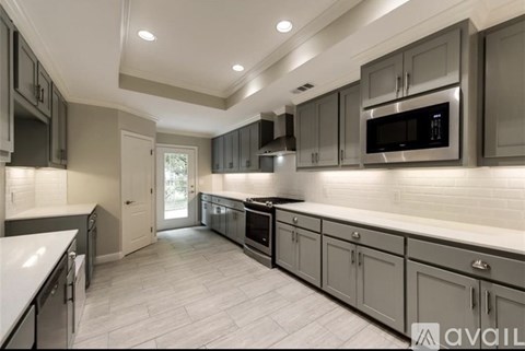 A modern kitchen with a white countertop and grey cabinets.