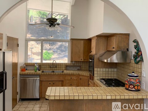 A kitchen with wooden cabinets and a tiled countertop.