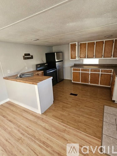 A kitchen with wooden floors and a white counter.