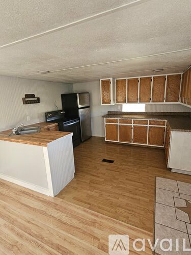 A kitchen with wooden cabinets and a white fridge.