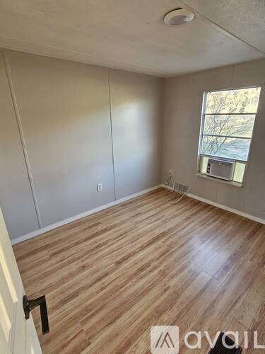 A room with wooden flooring and a window.