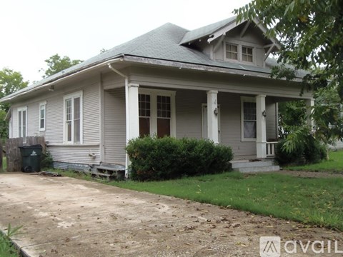 A house with a grey roof and a porch.