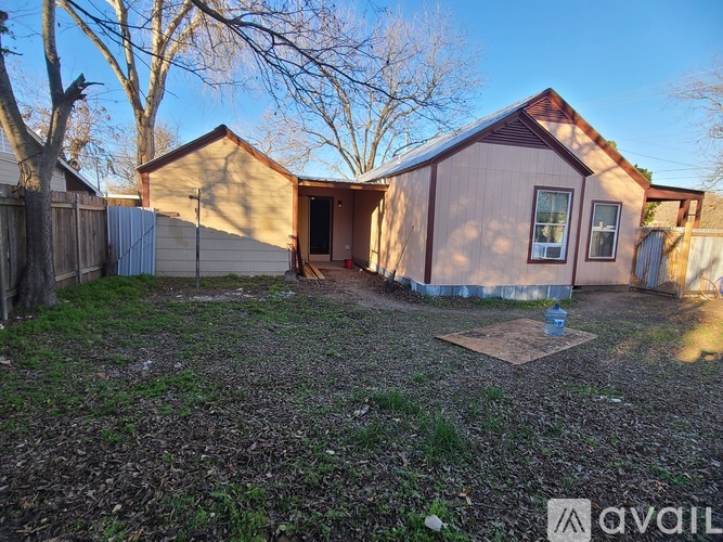 A small house with a brown roof and a brown fence.