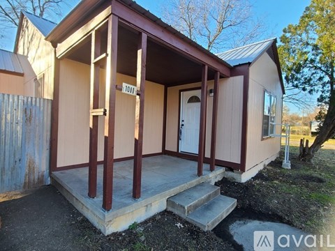 A small house with a porch and a door is numbered 1011.