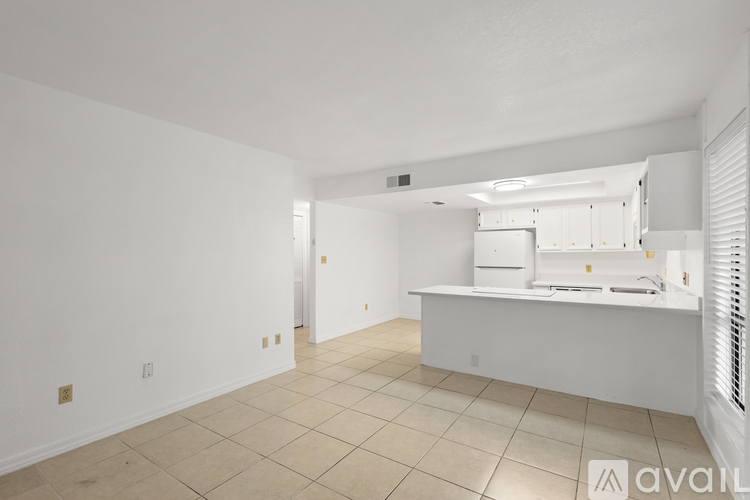 A spacious kitchen with white cabinets and a countertop.