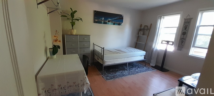 A bedroom with a bed, dresser, and window.