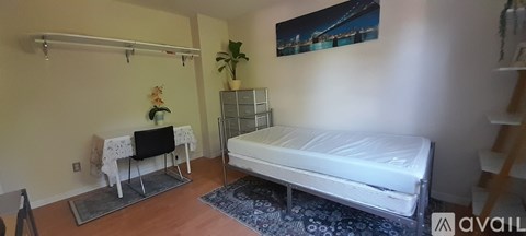 A bedroom with a bed, a chair, and a small table.