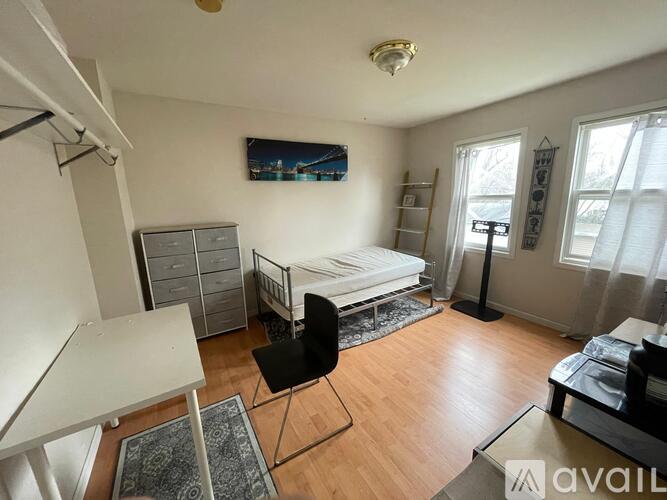 A bedroom with a bed, desk, and chair.