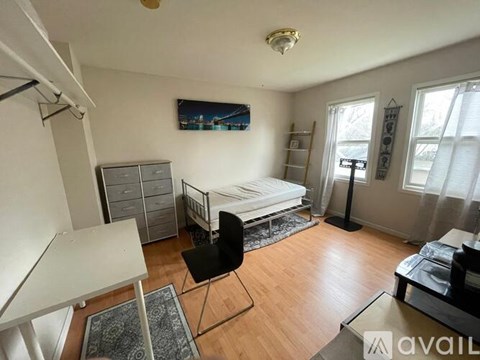 A bedroom with a bed, desk, and chair.