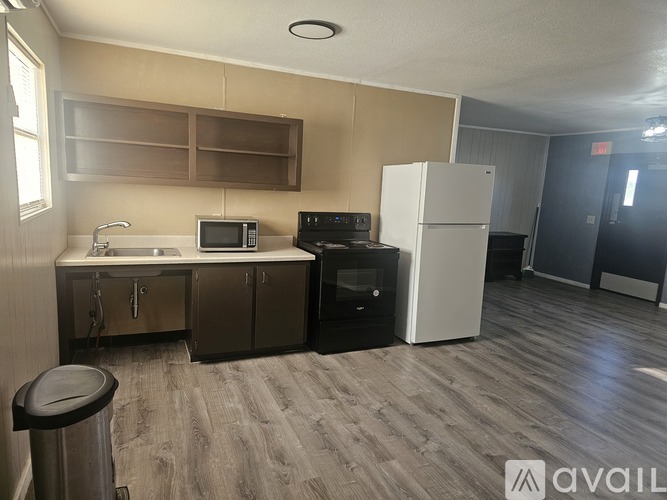 A kitchen with a sink, microwave, oven, and refrigerator.