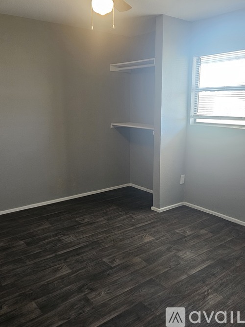 A room with a grey wall and a wooden floor.