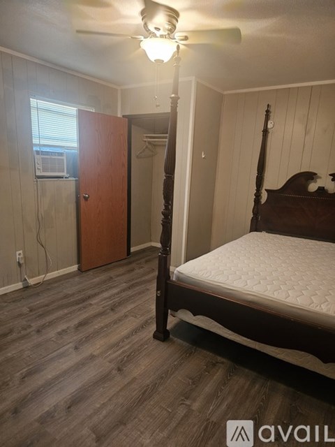A bedroom with a four poster bed and a window.