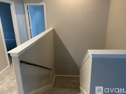 A staircase with a carpeted runner and a metal handrail.