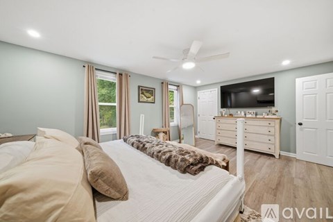 A bedroom with a large bed and a television in the corner.