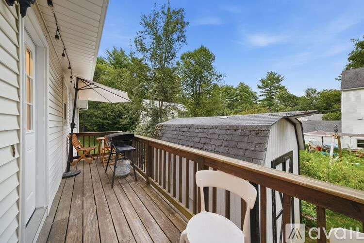A wooden deck with a white chair and a table.
