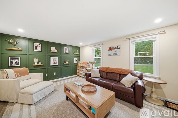 A living room with a brown couch, a white sofa, and a coffee table.