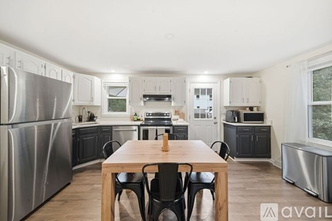 A modern kitchen with a wooden table and chairs.