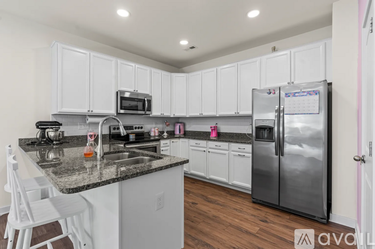 A kitchen with white cabinets and a granite countertop.