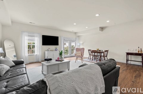 A modern living room with a black leather sofa and a television.