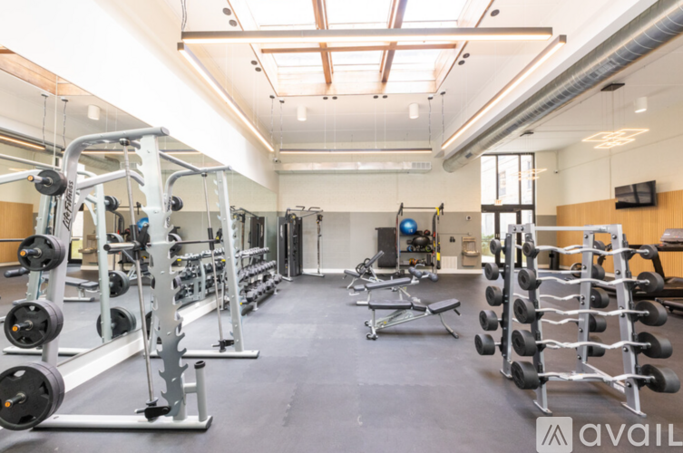 A gym with a variety of equipment including weights and benches.