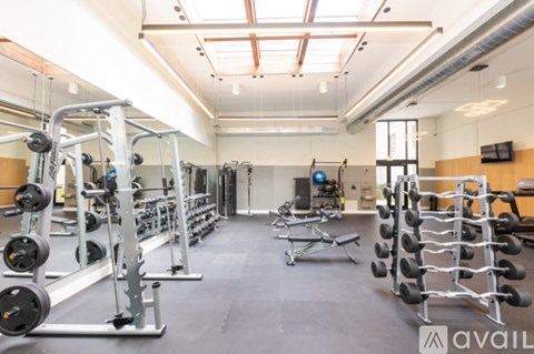 A gym with a variety of equipment including weights and benches.
