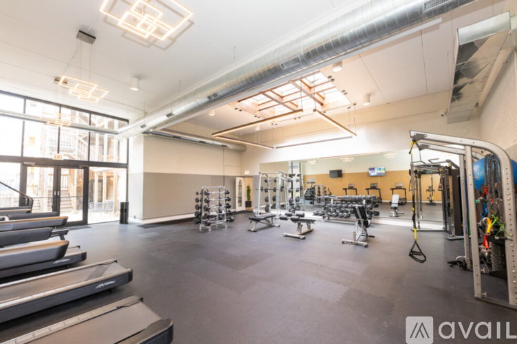 A gym with treadmills, weights, and exercise equipment.