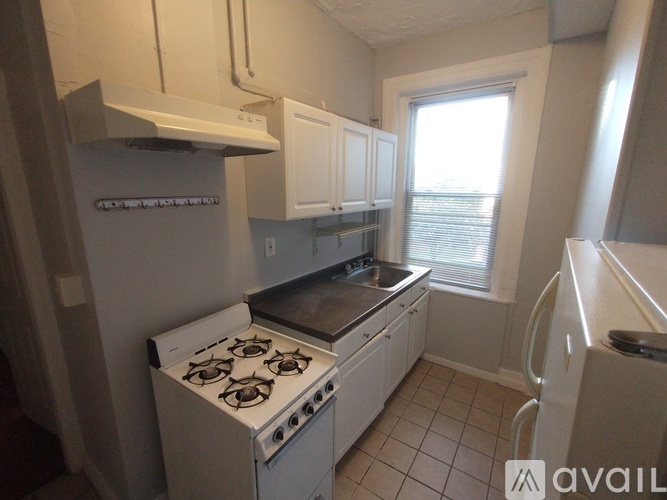 A small kitchen with white appliances and cabinets.
