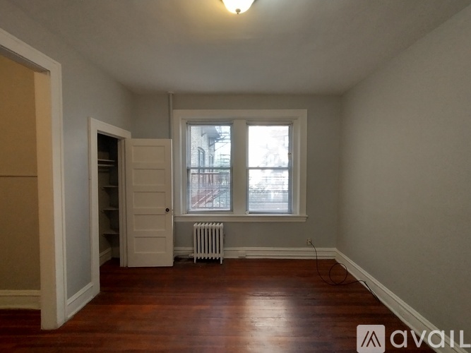 A room with a window and a radiator on the floor.