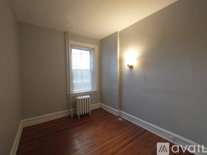 A room with a window and a radiator on the floor.