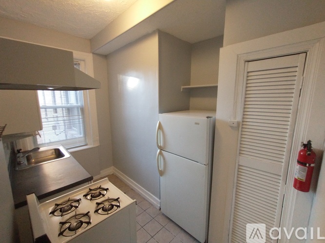 A kitchen with a stove, sink, and refrigerator.