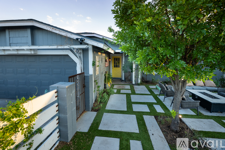 A house with a yellow door and a tree in the front yard.