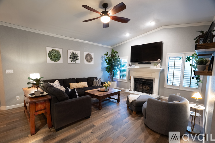 A living room with a fireplace and a television on the wall.