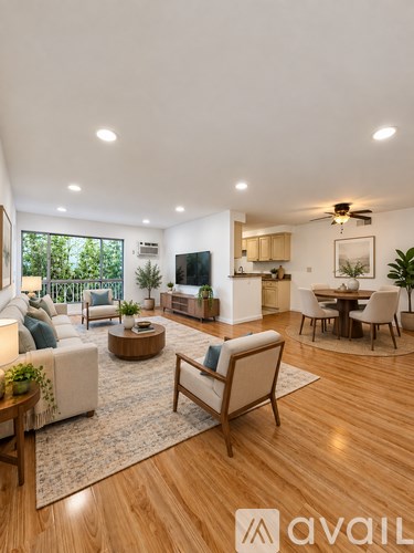 A living room with a sofa, a coffee table, a TV, and a dining table with chairs.