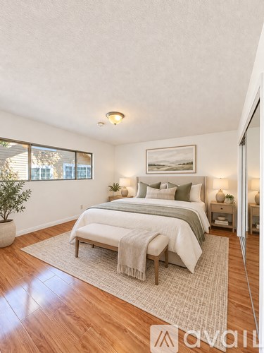 A bedroom with a bed, nightstands, and a rug.