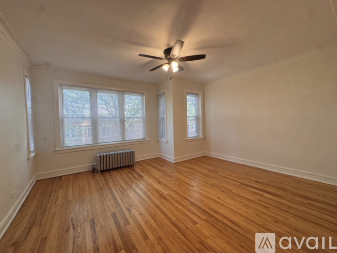 A room with wooden floors and a ceiling fan.
