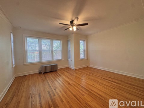 A room with wooden floors and a ceiling fan.