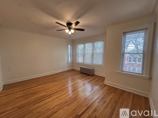 A room with wooden floors and a ceiling fan.
