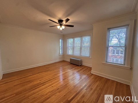 A room with wooden floors and a ceiling fan.
