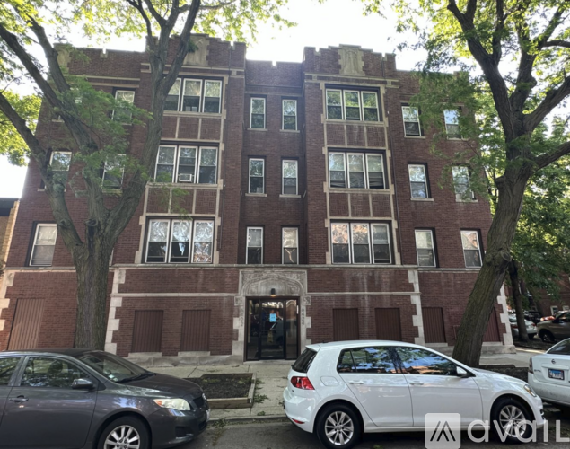A brick building with a white car parked in front.