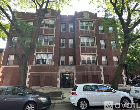 A brick building with a white car parked in front.